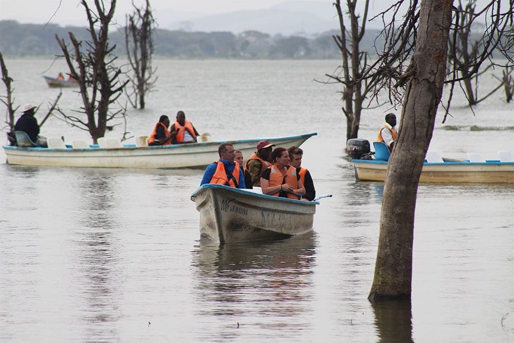 Packages 3 Tourists on a boat ride enjoying serene views of Lake Naivasha with hippos and birdlife