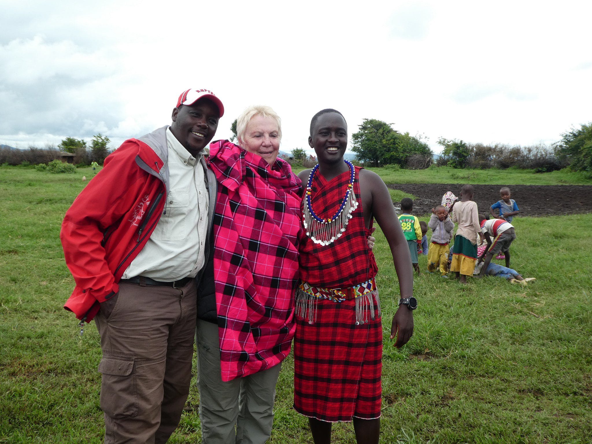 About 3 Luxury safari guests enjoying cultural experience with Maasai