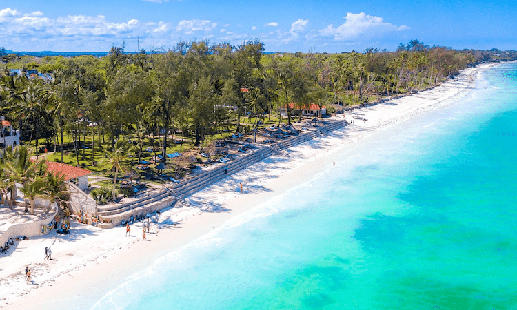 Packages 5 Deserted Diani Beach shoreline with soft turquoise waves and white sand under a clear sky